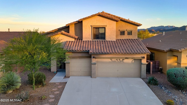 view of front of house with driveway, stucco siding, and a tiled roof