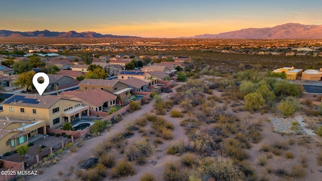 aerial view at dusk featuring a residential view and a mountain view