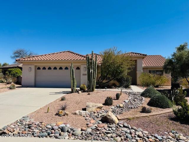 1370 N Birds Nest Rd, Green Valley, AZ 85614 - mediterranean / spanish-style home with an attached garage, driveway, a tile roof, and stucco siding