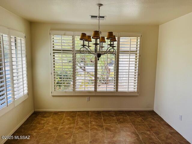 1370 N Birds Nest Rd, Green Valley, AZ 85614 - unfurnished dining area with baseboards, a chandelier, and visible vents