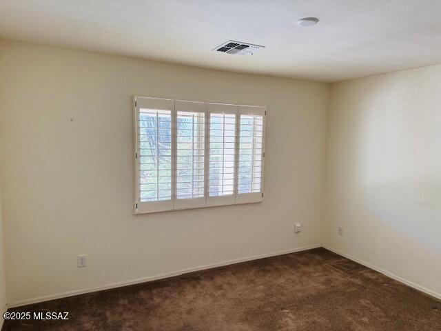 1370 N Birds Nest Rd, Green Valley, AZ 85614 - spare room featuring baseboards, visible vents, and dark carpet