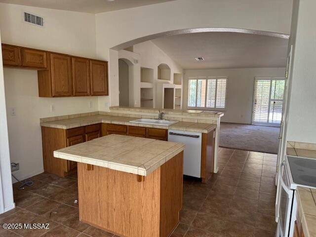 1370 N Birds Nest Rd, Green Valley, AZ 85614 - kitchen with a peninsula, a kitchen island, white appliances, brown cabinets, and a sink