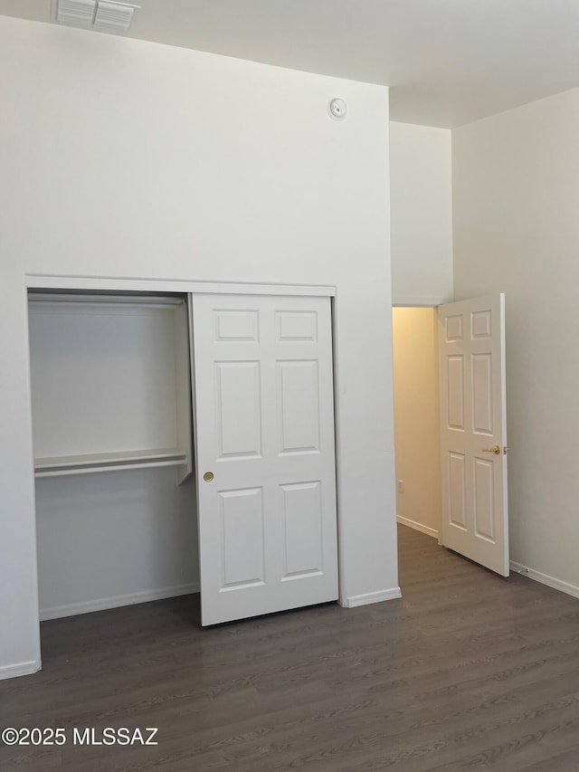 6610 S Via Molino De Viento, Tucson, AZ 85757 - unfurnished bedroom featuring a closet, dark wood-style floors, and baseboards