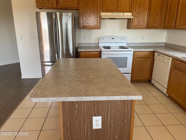 6610 S Via Molino De Viento, Tucson, AZ 85757 - kitchen featuring white appliances, under cabinet range hood, a center island, and light tile patterned floors