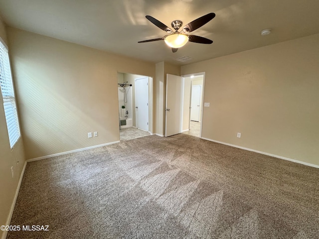 interior space with baseboards, carpet flooring, connected bathroom, and ceiling fan