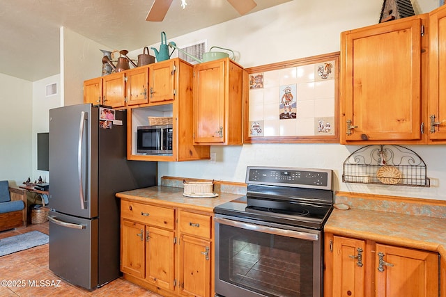 kitchen featuring light countertops, stainless steel appliances, light tile patterned floors, visible vents, and ceiling fan