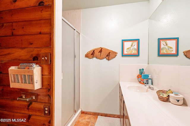 full bathroom with tile patterned floors, vanity, baseboards, and a shower stall