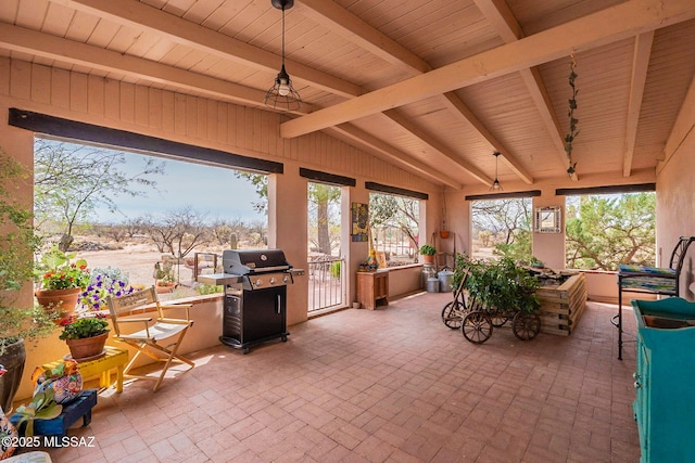 sunroom / solarium featuring vaulted ceiling with beams and brick floor