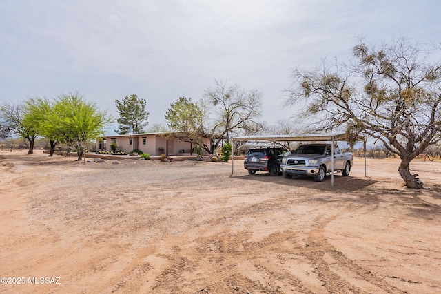exterior space featuring dirt driveway and a detached carport