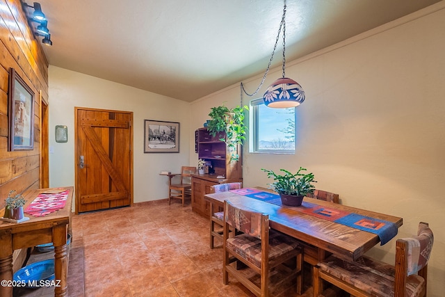dining space featuring light tile patterned flooring and lofted ceiling