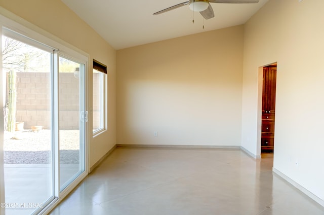 unfurnished room featuring concrete floors, vaulted ceiling, baseboards, and ceiling fan
