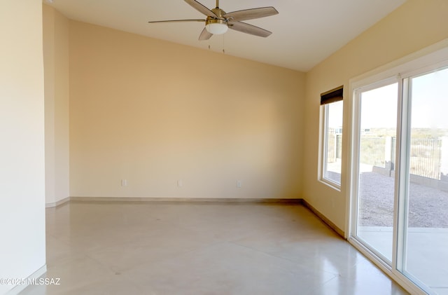 empty room featuring concrete flooring, a wealth of natural light, baseboards, and ceiling fan
