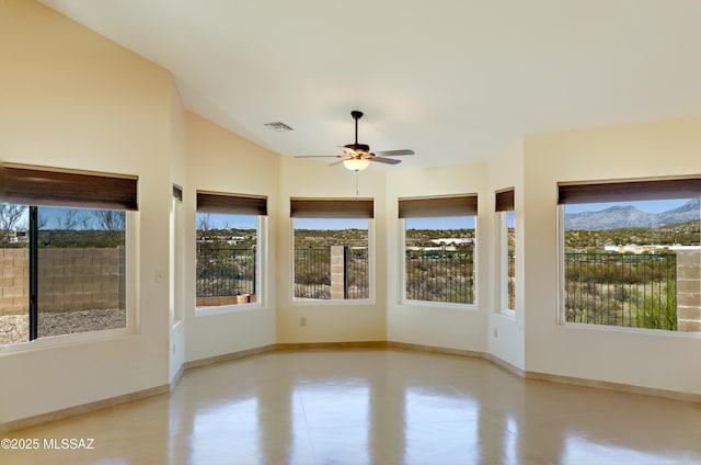 unfurnished sunroom featuring a mountain view, a wealth of natural light, baseboards, and visible vents