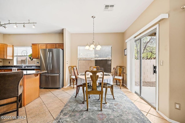 15046 S Harry Truman Pl, Sahuarita, AZ 85629 - dining room with a chandelier, light tile patterned flooring, baseboards, and rail lighting