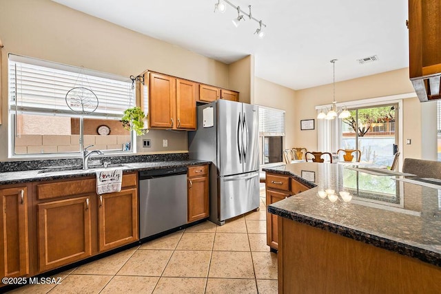 15046 S Harry Truman Pl, Sahuarita, AZ 85629 - kitchen featuring appliances with stainless steel finishes, a sink, a chandelier, brown cabinetry, and decorative light fixtures