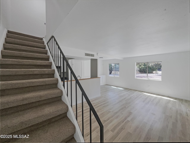 6588 Calle La Paz Unit C, Tucson, AZ 85715 - stairs with baseboards, visible vents, and wood finished floors