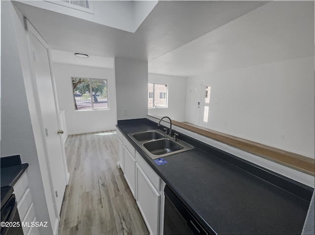 6588 Calle La Paz Unit C, Tucson, AZ 85715 - kitchen with a sink, dark countertops, light wood finished floors, dishwasher, and white cabinets