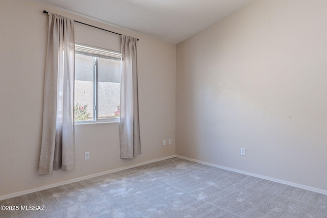carpeted spare room with baseboards