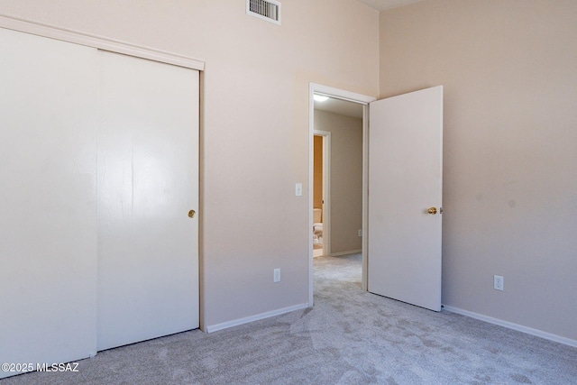 unfurnished bedroom with carpet, visible vents, a closet, and baseboards