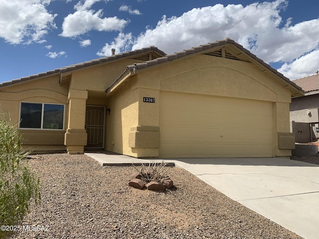 ranch-style house with a garage, stucco siding, driveway, and a tile roof
