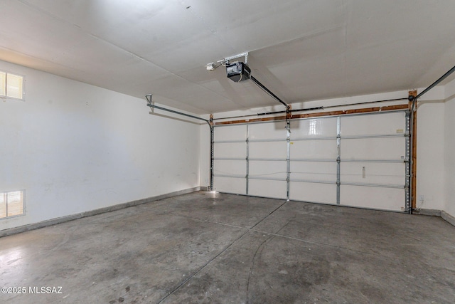 garage featuring a garage door opener, baseboards, and visible vents