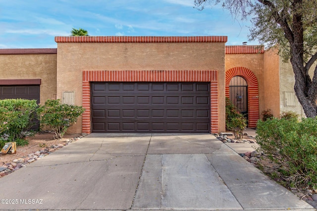 view of front of property featuring stucco siding, a garage, and concrete driveway