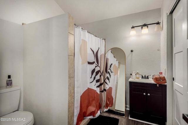 full bathroom with a shower with shower curtain, wood finished floors, toilet, and vanity