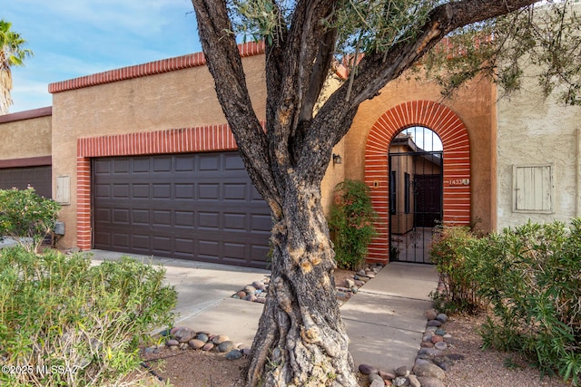 view of front of home with stucco siding, an attached garage, and concrete driveway