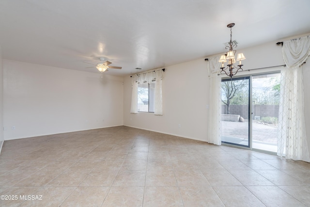 spare room featuring light tile patterned floors, baseboards, and ceiling fan with notable chandelier