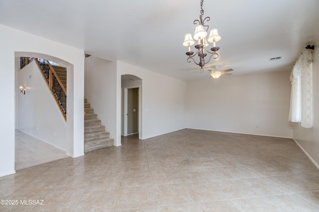 spare room featuring visible vents, stairway, arched walkways, ceiling fan with notable chandelier, and light tile patterned floors