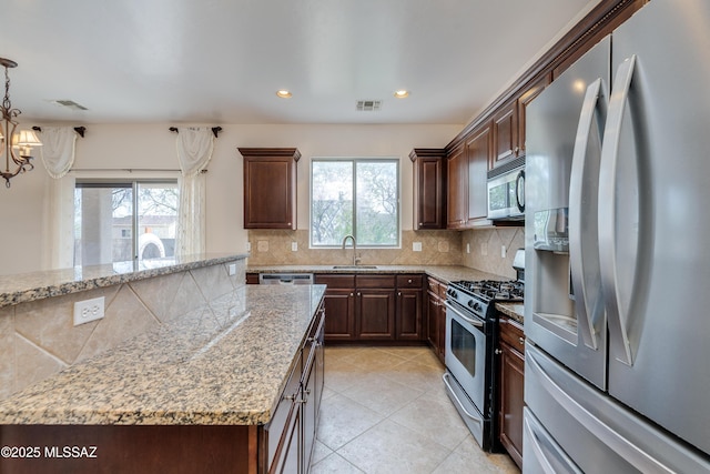 kitchen with a sink, visible vents, backsplash, and appliances with stainless steel finishes