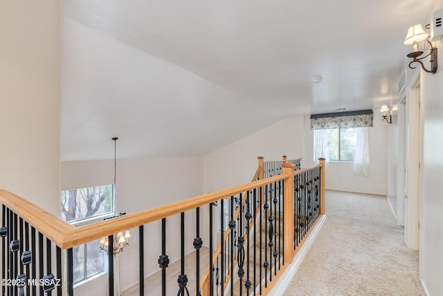 corridor featuring an upstairs landing, carpet, and lofted ceiling