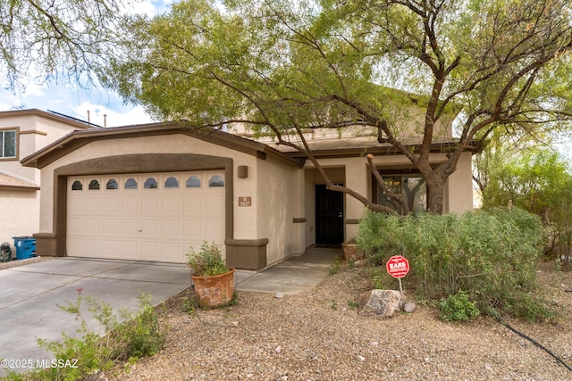 view of front facade featuring stucco siding, driveway, and a garage