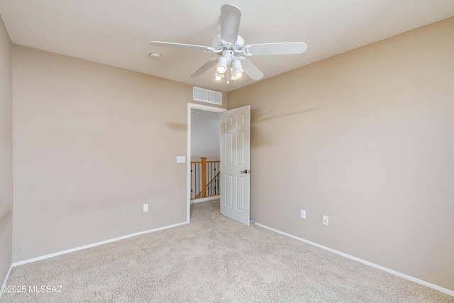 empty room featuring a ceiling fan, carpet floors, baseboards, and visible vents