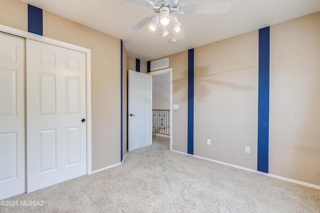 unfurnished bedroom with a ceiling fan, carpet, baseboards, and visible vents