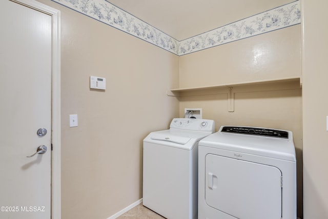 laundry area with baseboards, separate washer and dryer, and laundry area