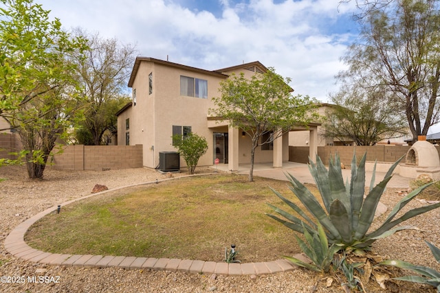 back of house with stucco siding, a fenced backyard, cooling unit, and a patio area