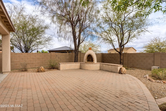 view of patio / terrace with exterior fireplace and a fenced backyard
