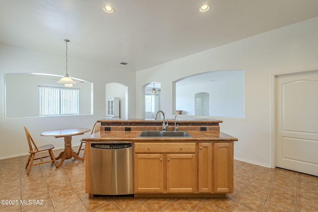 kitchen with light tile patterned flooring, hanging light fixtures, a sink, dishwasher, and arched walkways