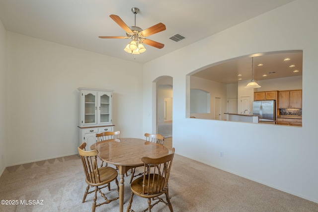 dining space with visible vents, light carpet, ceiling fan, recessed lighting, and arched walkways