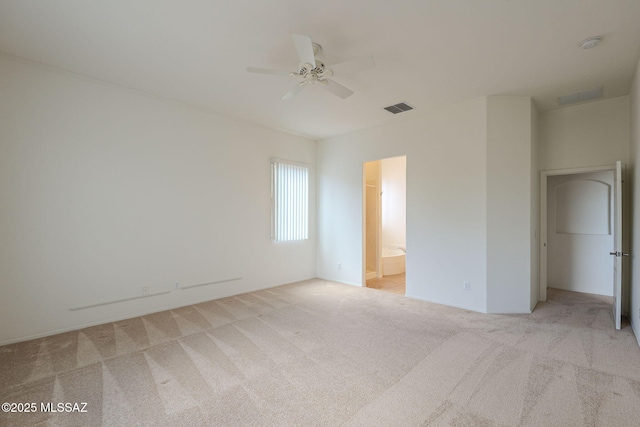 unfurnished bedroom with visible vents, a ceiling fan, carpet, and ensuite bath