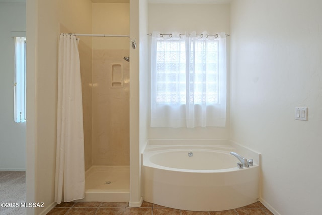 bathroom featuring tile patterned flooring, a shower stall, and a garden tub