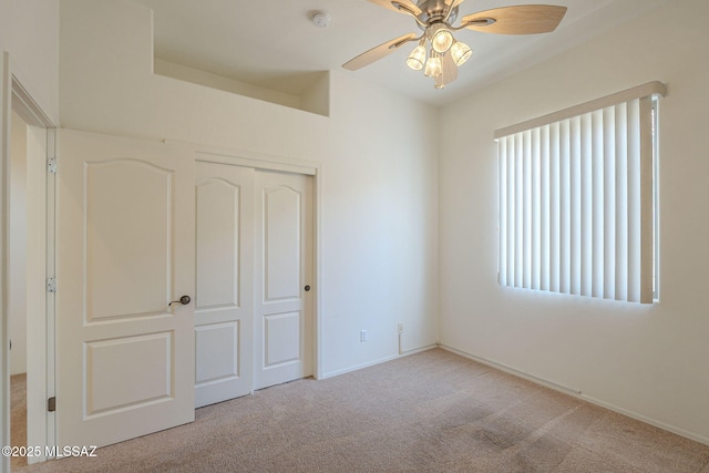 unfurnished bedroom featuring carpet flooring, baseboards, ceiling fan, and a closet