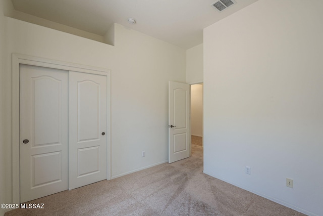 unfurnished bedroom featuring a closet, baseboards, carpet flooring, and visible vents