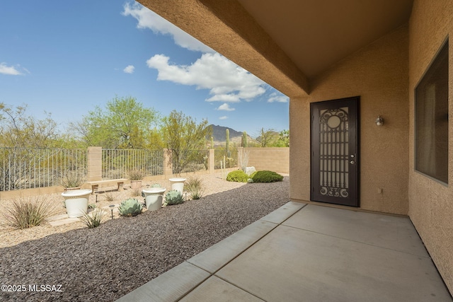 view of patio / terrace with a mountain view and fence