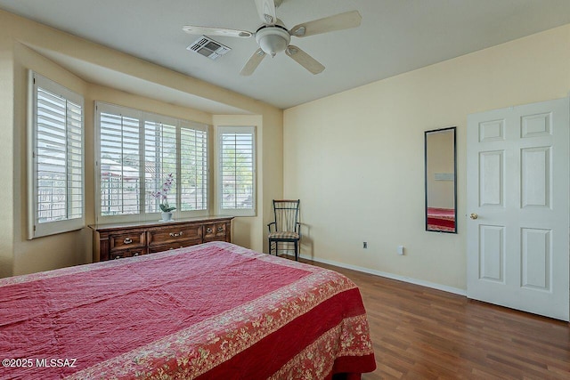 bedroom featuring baseboards, visible vents, a ceiling fan, and wood finished floors