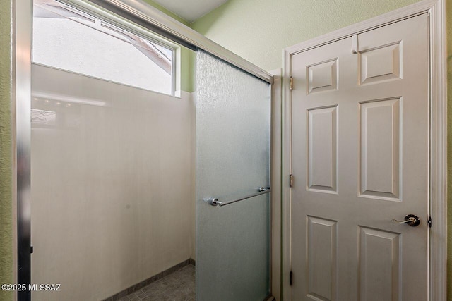 bathroom featuring a shower with door