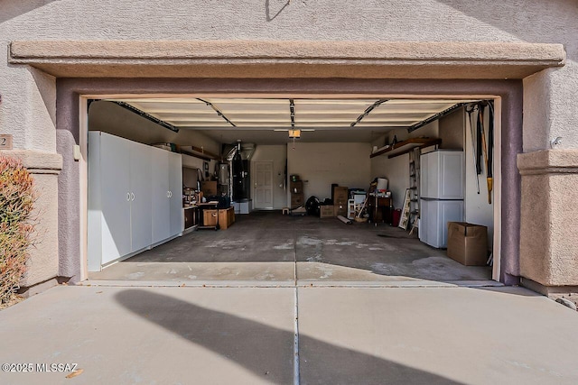 garage with refrigerator, driveway, and a garage door opener