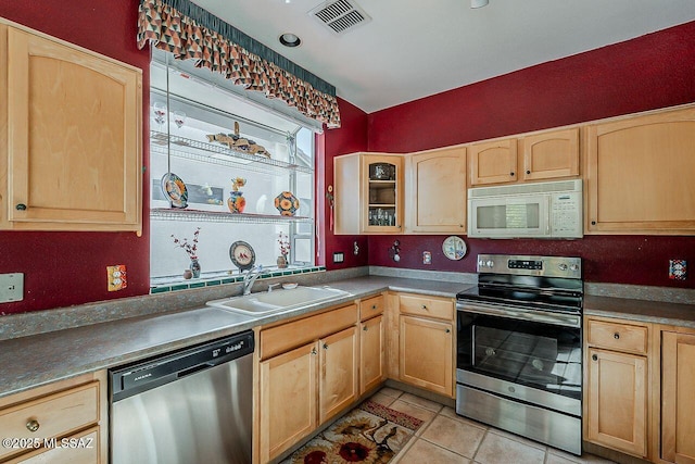 kitchen with visible vents, light brown cabinetry, a sink, and stainless steel appliances