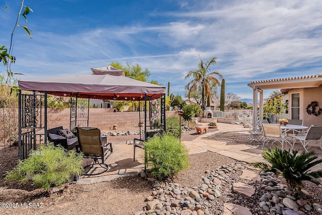 view of patio / terrace with a gazebo, outdoor dining area, and fence